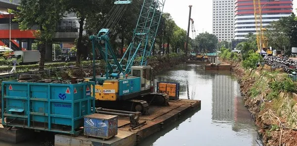 Para pekerja menyelesaikan proyek penguatan tanggul turap di kawasan Kuningan, Jakarta Selatan, Selasa (21/4/2026).