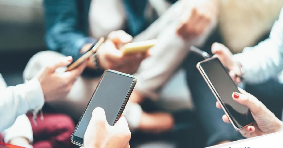 Ilustrasi sekelompok teman asyik menggunakan smartphone, menggambarkan era digital yang akan bergeser ke perangkat wearable.
