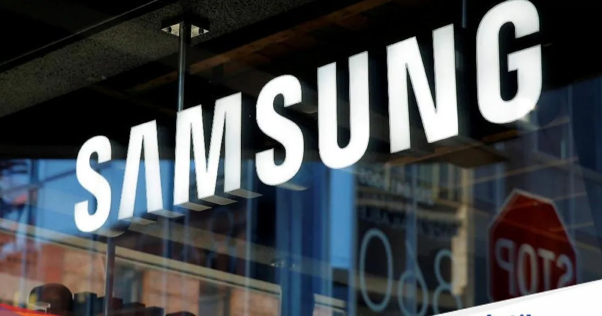Seorang pria berjalan di depan logo Samsung Electronics di kantor pusat perusahaan di Seoul